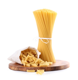 Photo of Wooden board with spaghetti and fusilli pasta isolated on white