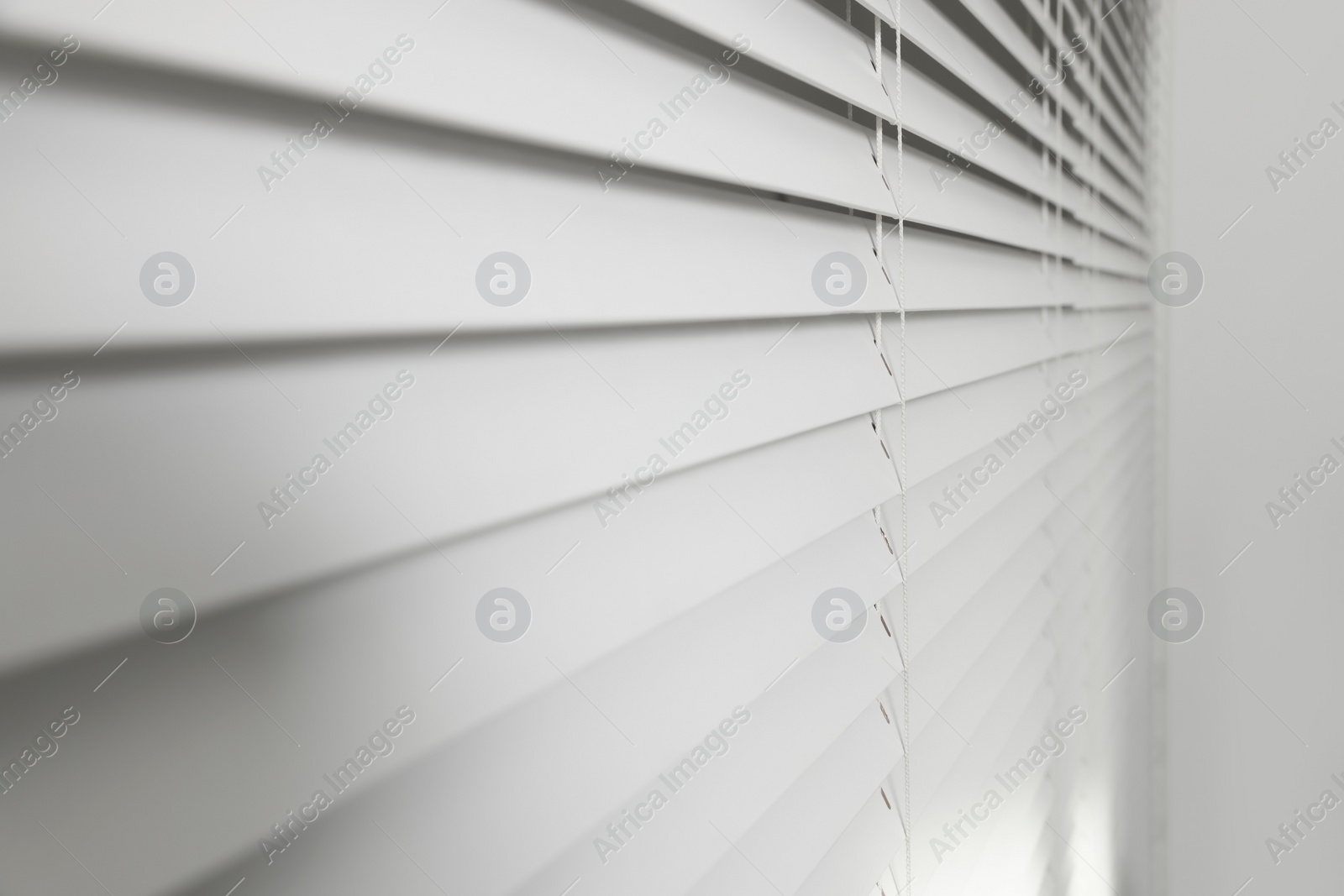 Photo of Closeup view of horizontal blinds on window indoors
