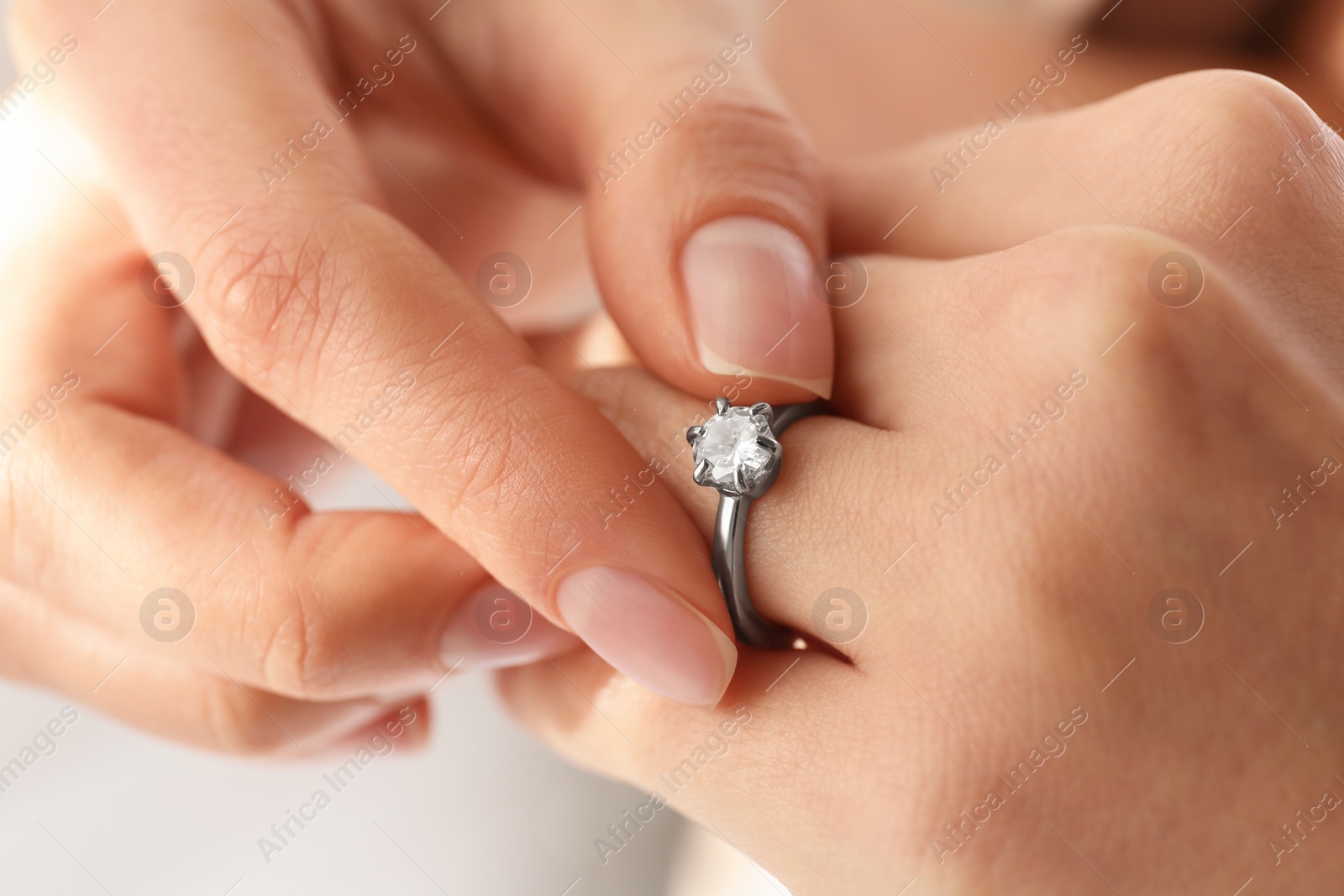 Photo of Young woman wearing beautiful engagement ring, closeup