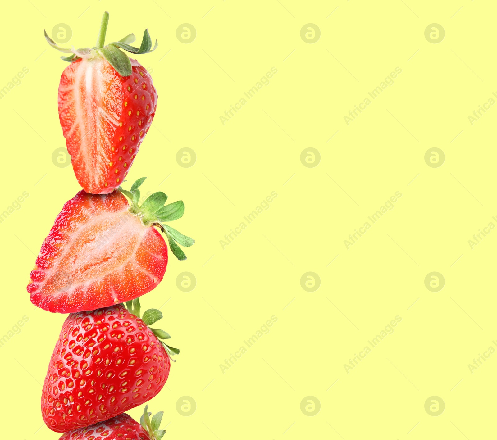 Image of Stack of fresh strawberries on light yellow background, space for text