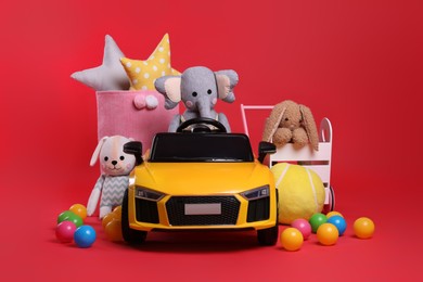 Photo of Child's electric car with other toys on red background