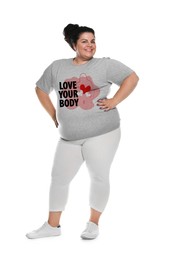 Image of Smiling plus-size model in t-shirt with outline of woman figure, hearts and phrase Love Your Body on white background