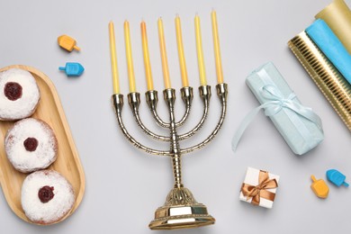 Photo of Flat lay composition with Hanukkah menorah and gift boxes on light grey background