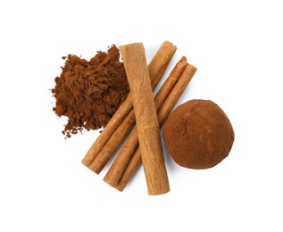 Photo of Delicious chocolate truffle with cocoa powder and cinnamon sticks on white background, top view