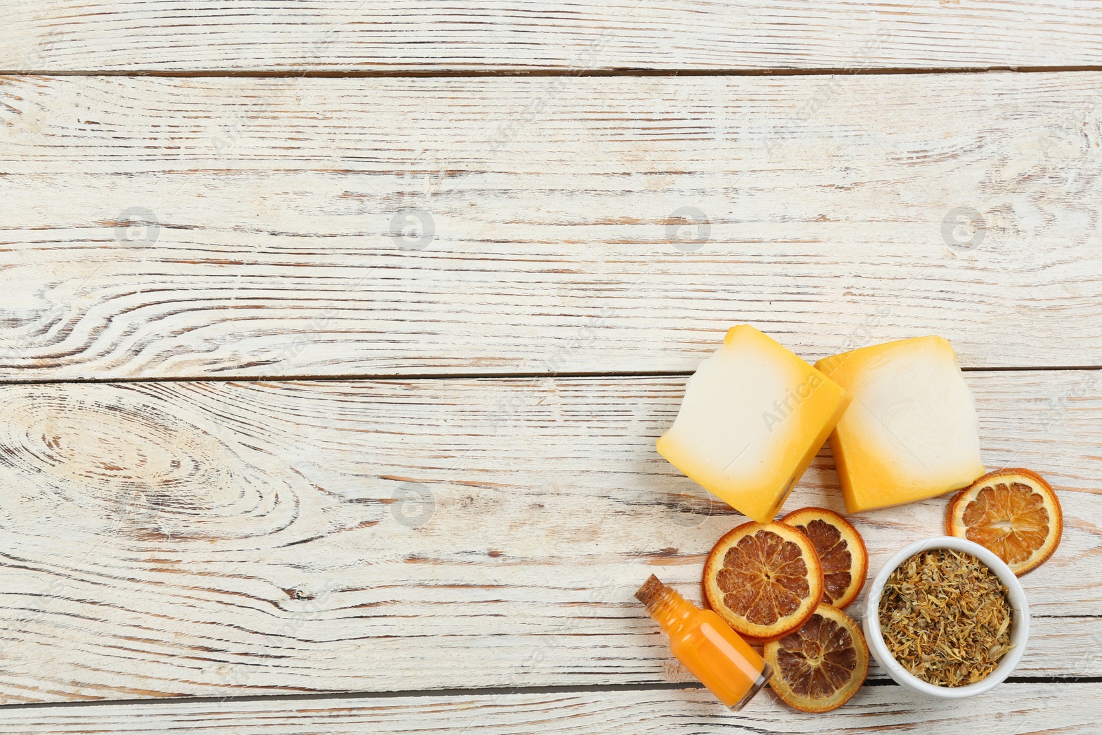 Photo of Flat lay composition with natural handmade soap and ingredients on white wooden table, space for text