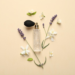Photo of Flat lay composition with elegant perfume and beautiful flowers on beige background