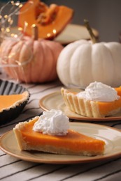 Photo of Fresh homemade pumpkin pie with whipped cream on table