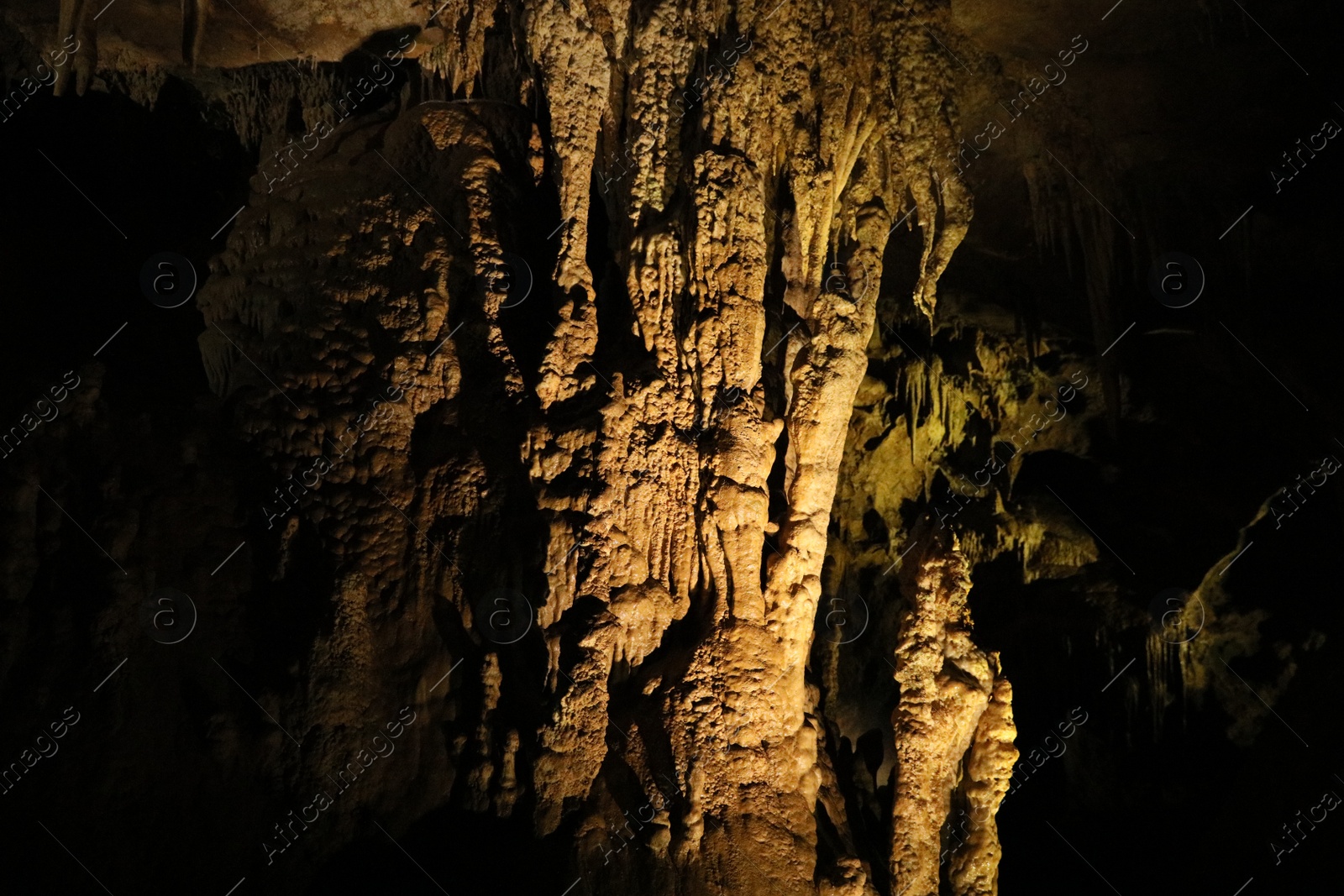 Photo of Picturesque view of many stalactite and stalagmite formations in cave