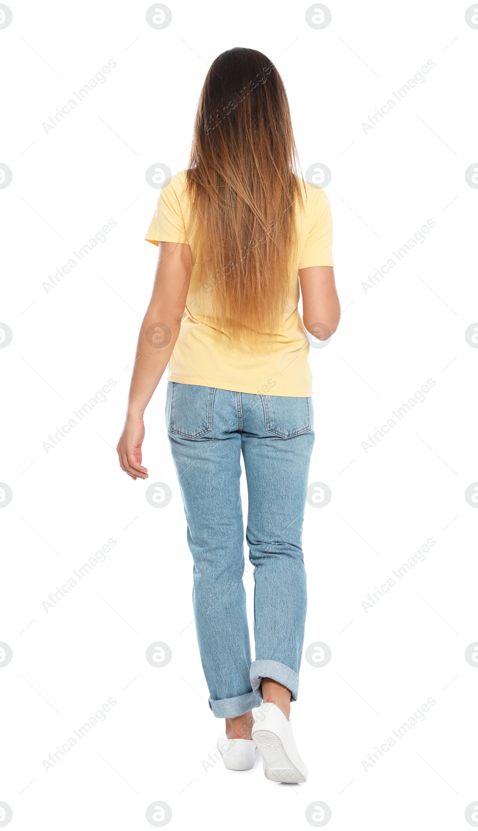 Photo of Woman in casual outfit walking on white background, back view