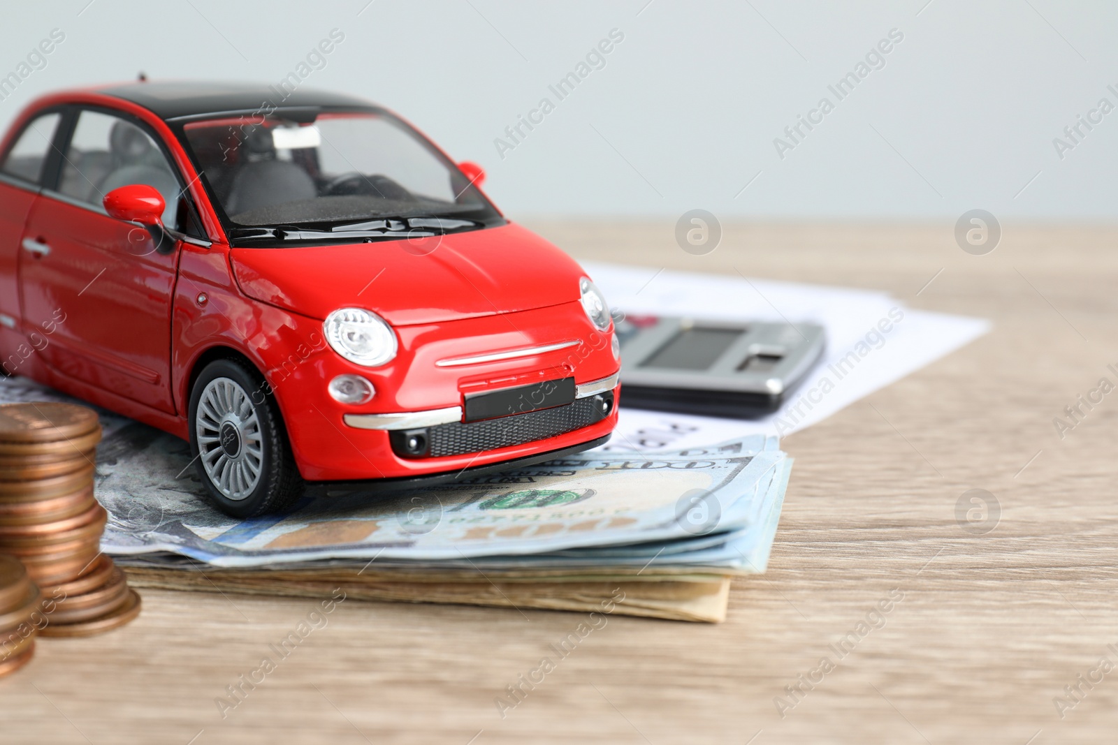 Photo of Toy car and money on table, space for text. Vehicle insurance