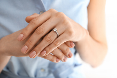 Photo of Young woman wearing beautiful engagement ring, closeup