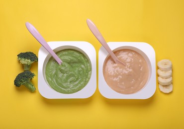 Bowls with healthy baby food and ingredients on yellow background, flat lay