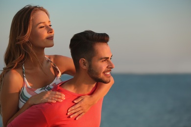 Photo of Happy young couple playing together on beach