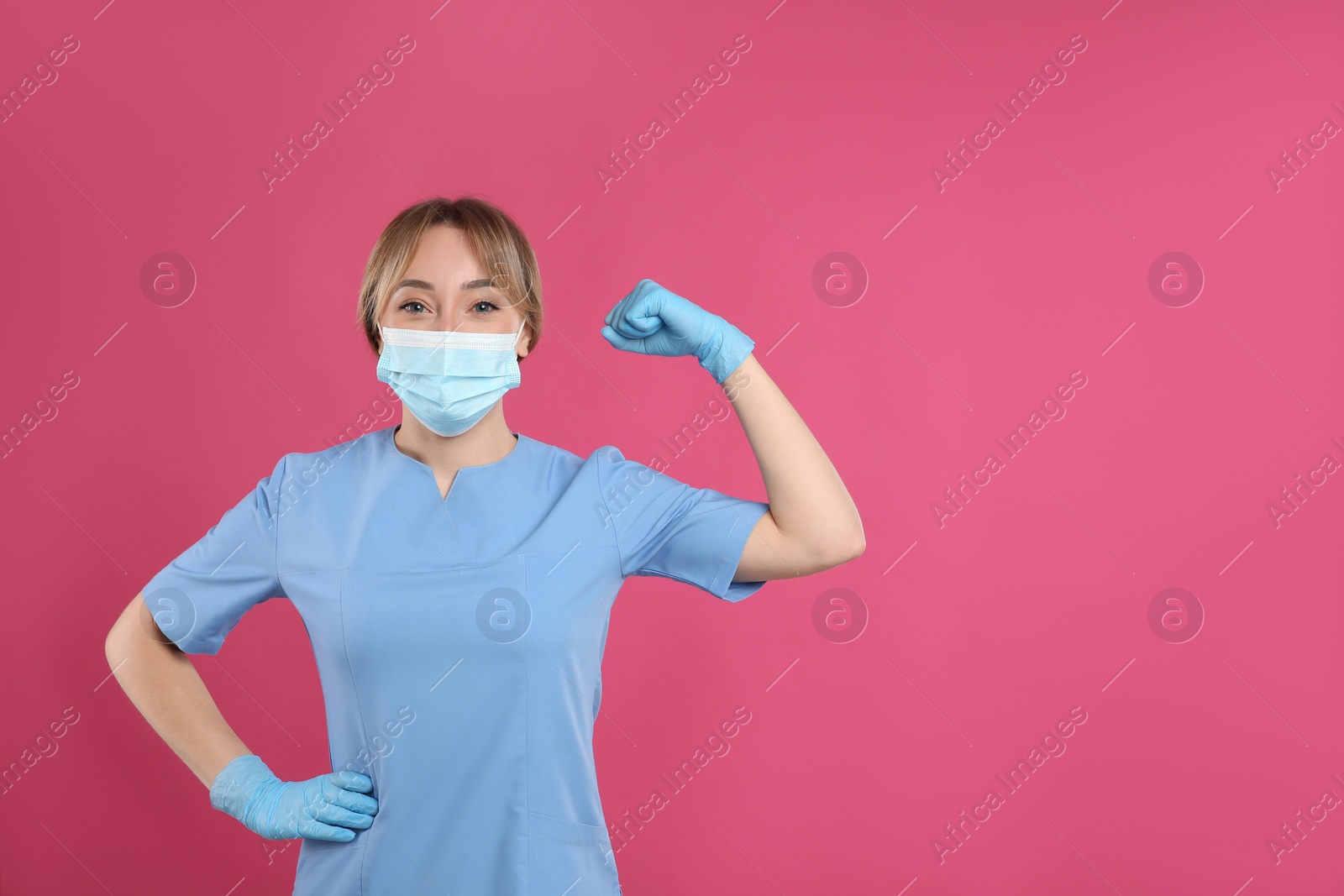 Photo of Doctor with protective mask showing muscles on pink background, space for text. Strong immunity concept