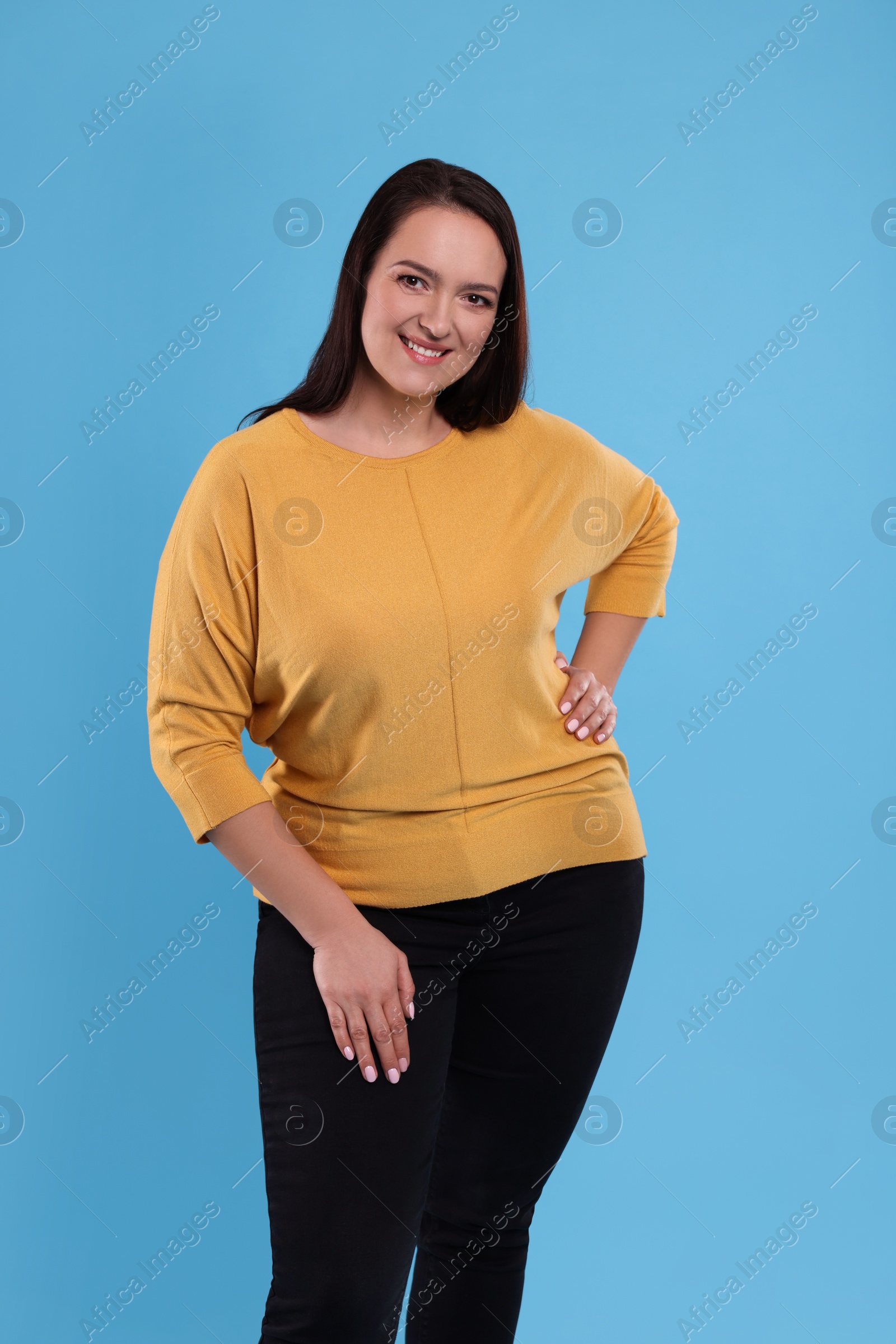 Photo of Beautiful overweight woman with charming smile on turquoise background