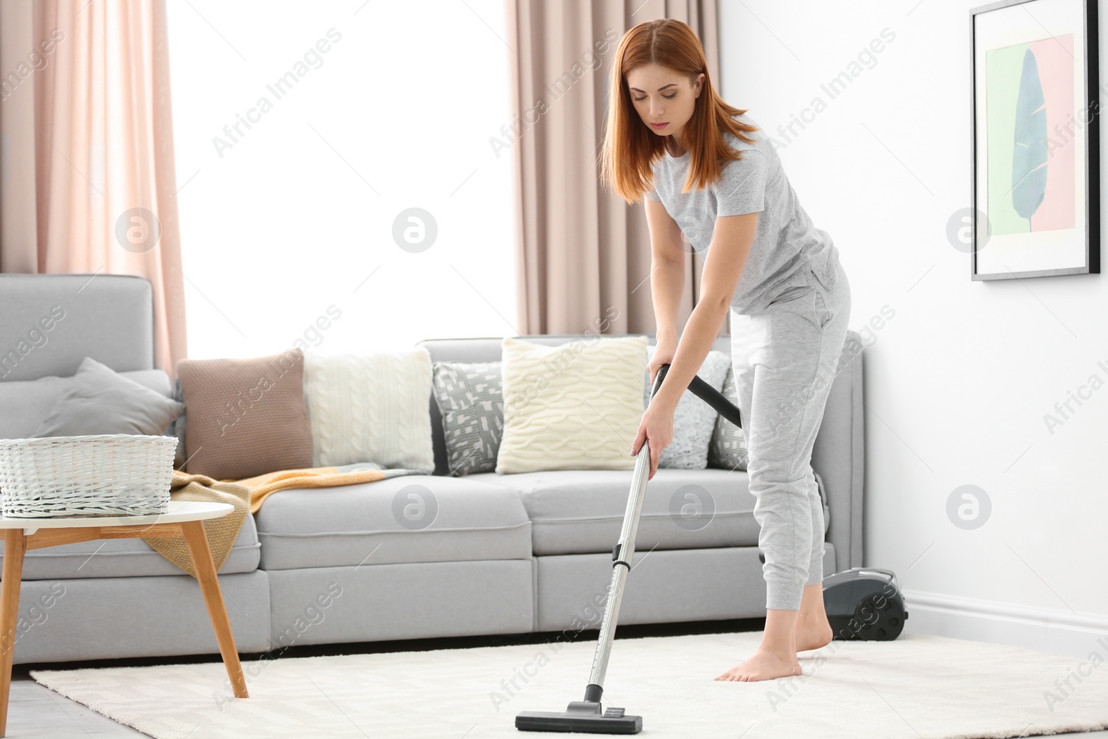 Photo of Housewife hoovering carpet at home