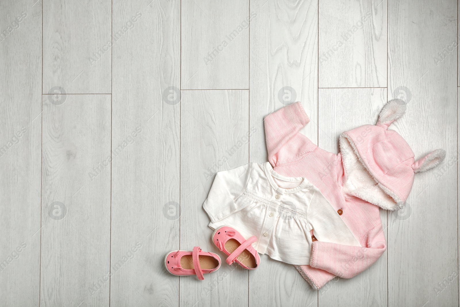 Photo of Flat lay composition with cute clothes and space for text on wooden background. Baby accessories