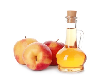 Photo of Glass jug of vinegar and fresh apples on white background