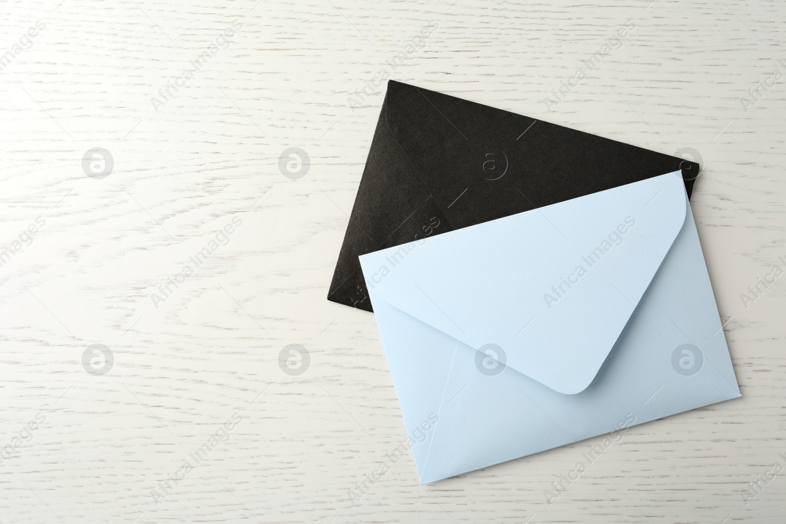 Photo of Paper envelopes on white wooden background, flat lay. Space for text