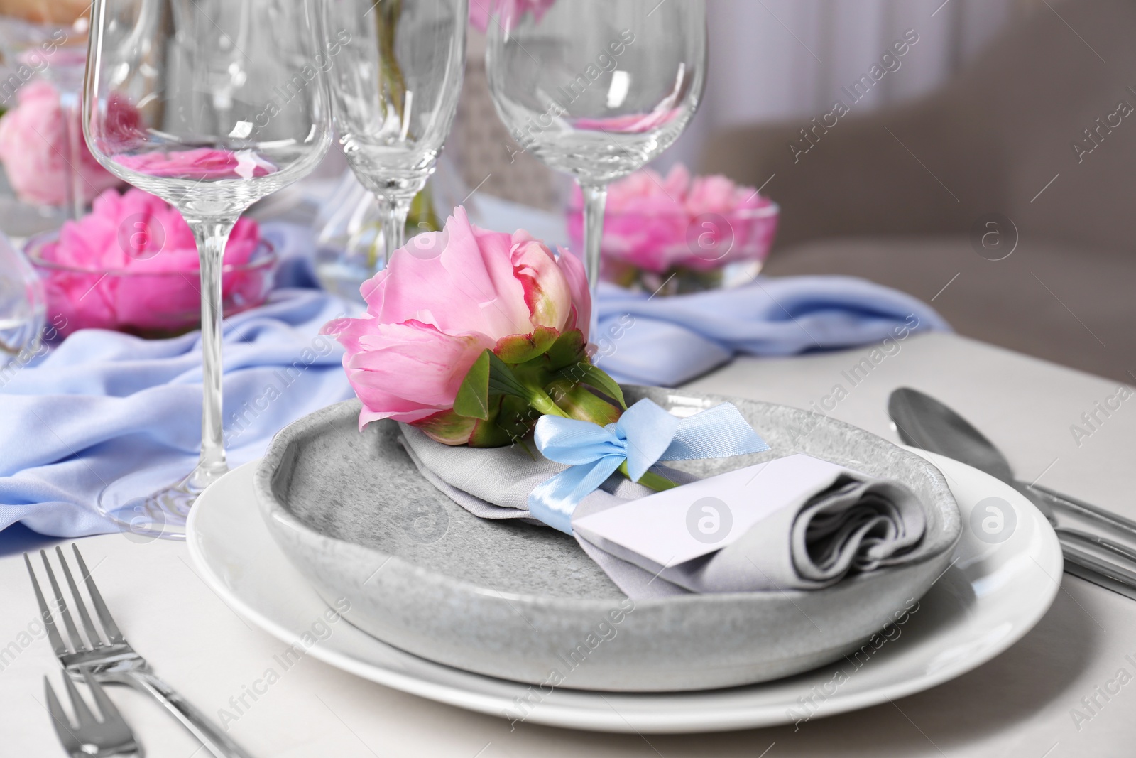 Photo of Stylish table setting with beautiful peonies, napkin and blank card indoors, closeup