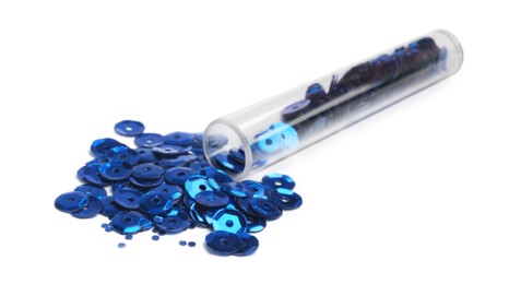 Photo of Many blue sequins and tube on white background