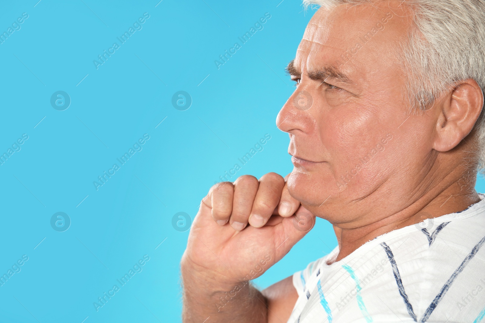 Photo of Mature man with double chin on blue background. Space for text