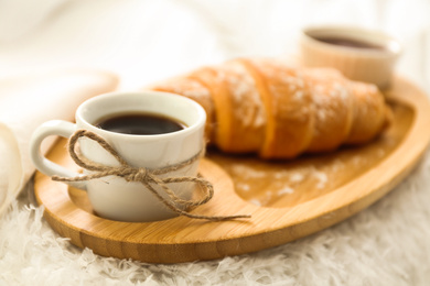 Photo of Delicious morning coffee and croissant on bed