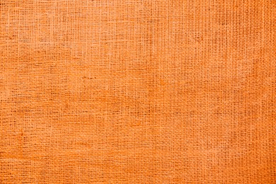 Texture of orange burlap fabric as background, top view