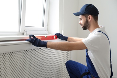 Photo of Handyman working with building level indoors. Professional construction tools