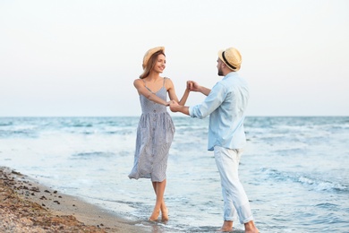 Photo of Happy young couple dancing on beautiful beach