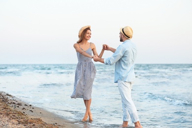 Happy young couple dancing on beautiful beach