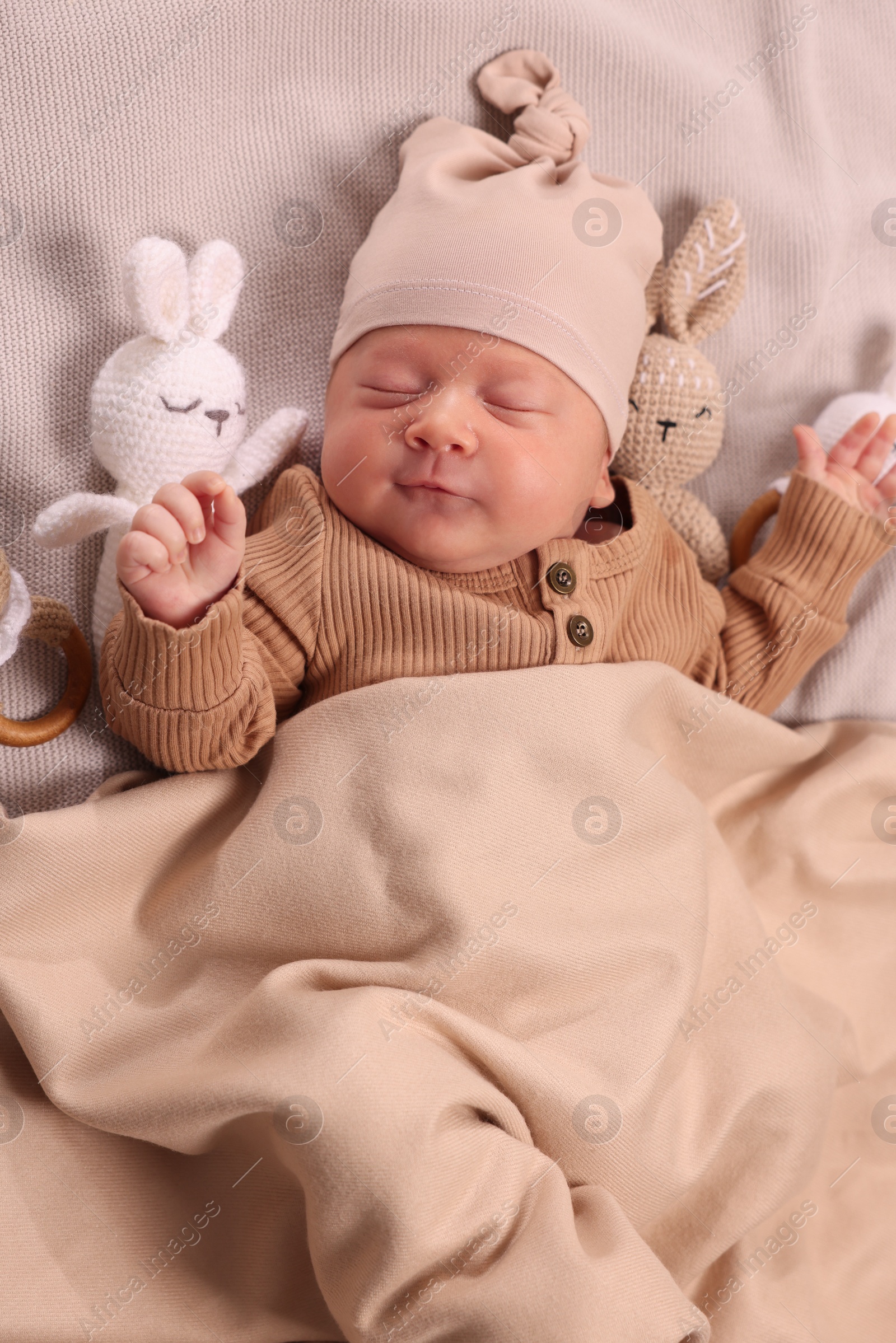 Photo of Cute newborn baby sleeping with toys on blanket, top view