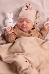 Photo of Cute newborn baby sleeping with toys on blanket, top view