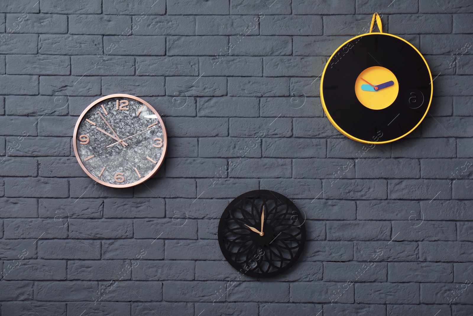 Photo of Different clocks on brick wall. Time concept