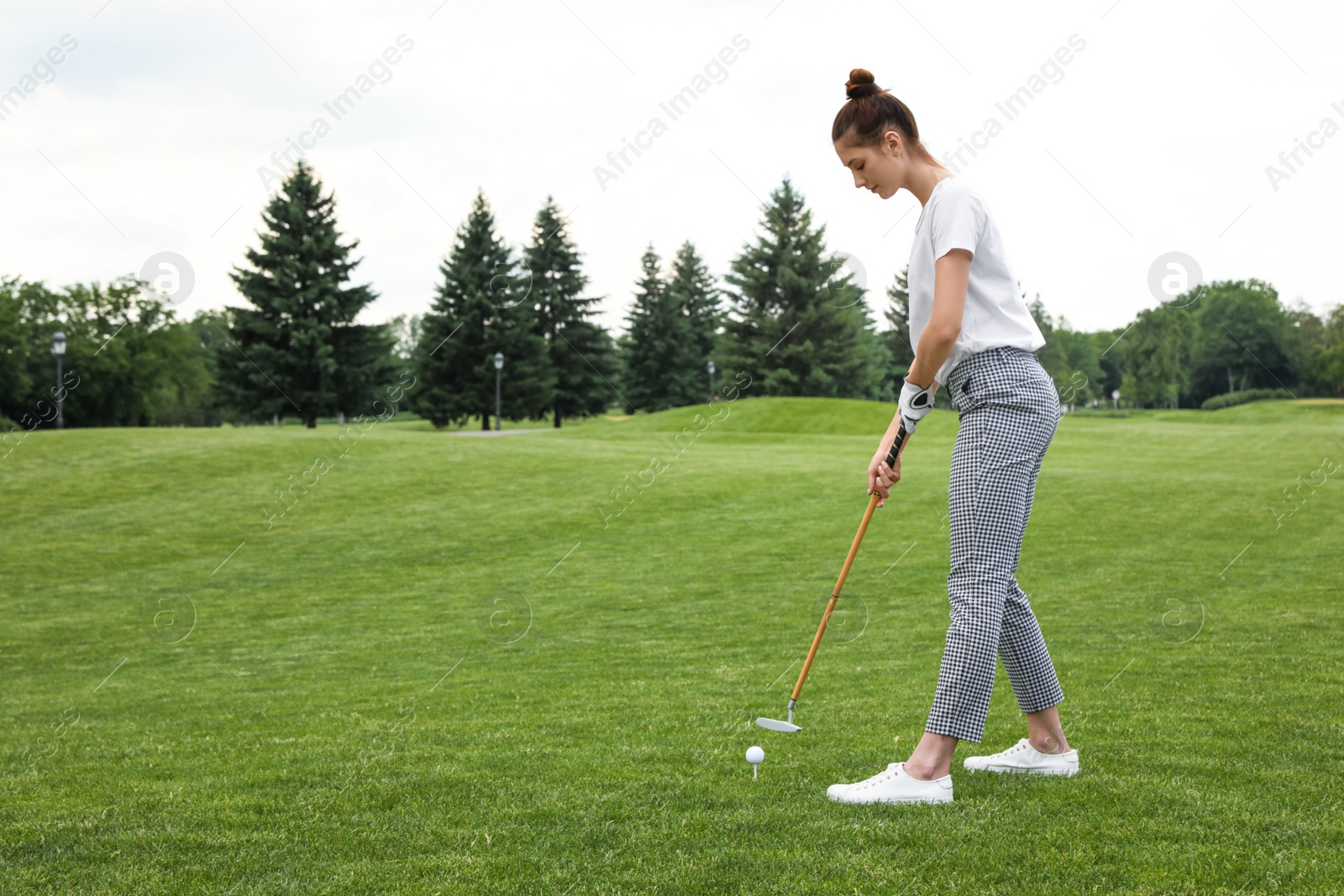 Photo of Woman playing golf on green course. Sport and leisure