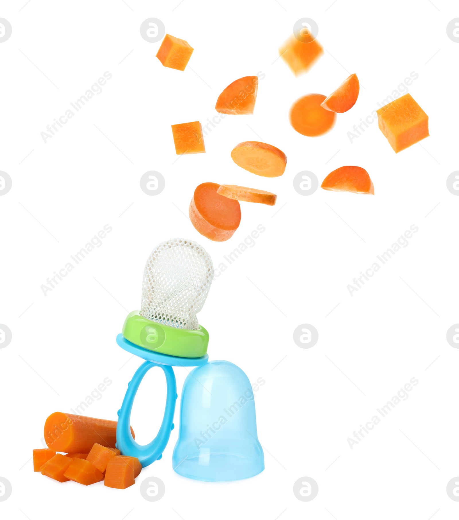 Image of Empty nibbler and pieces of boiled carrot falling on white background. Baby feeder