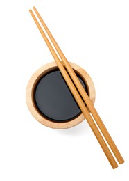 Tasty soy sauce in bowl and chopsticks isolated on white, top view