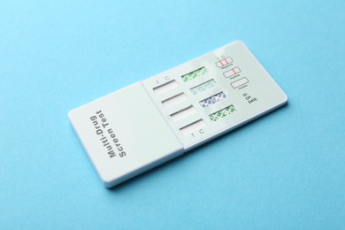 Photo of Multi-drug screen test on light blue background, closeup