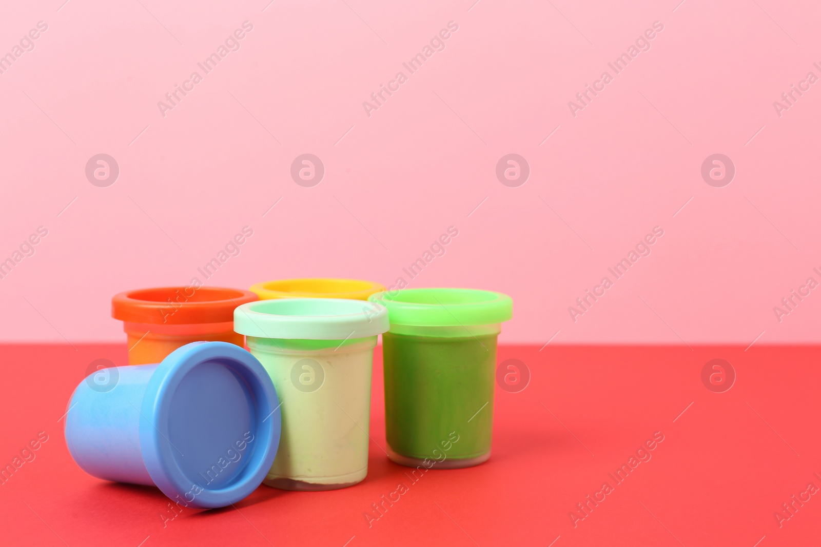 Photo of Different bright play dough on color background. Space for text