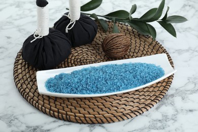 Photo of Composition with blue sea salt and herbal bags on white marble table