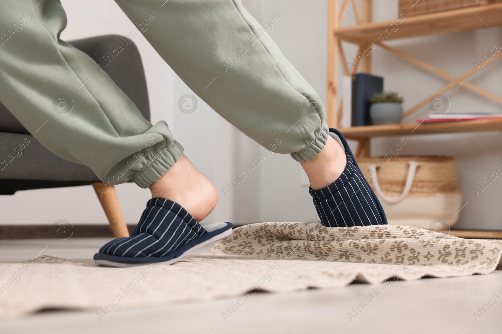 Photo of Man tripping over rug at home, closeup