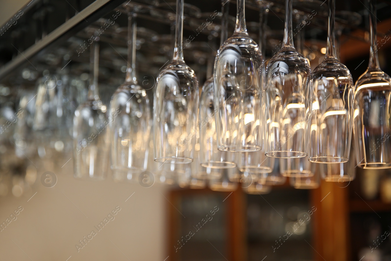 Photo of Many clean glasses on metal rack in restaurant