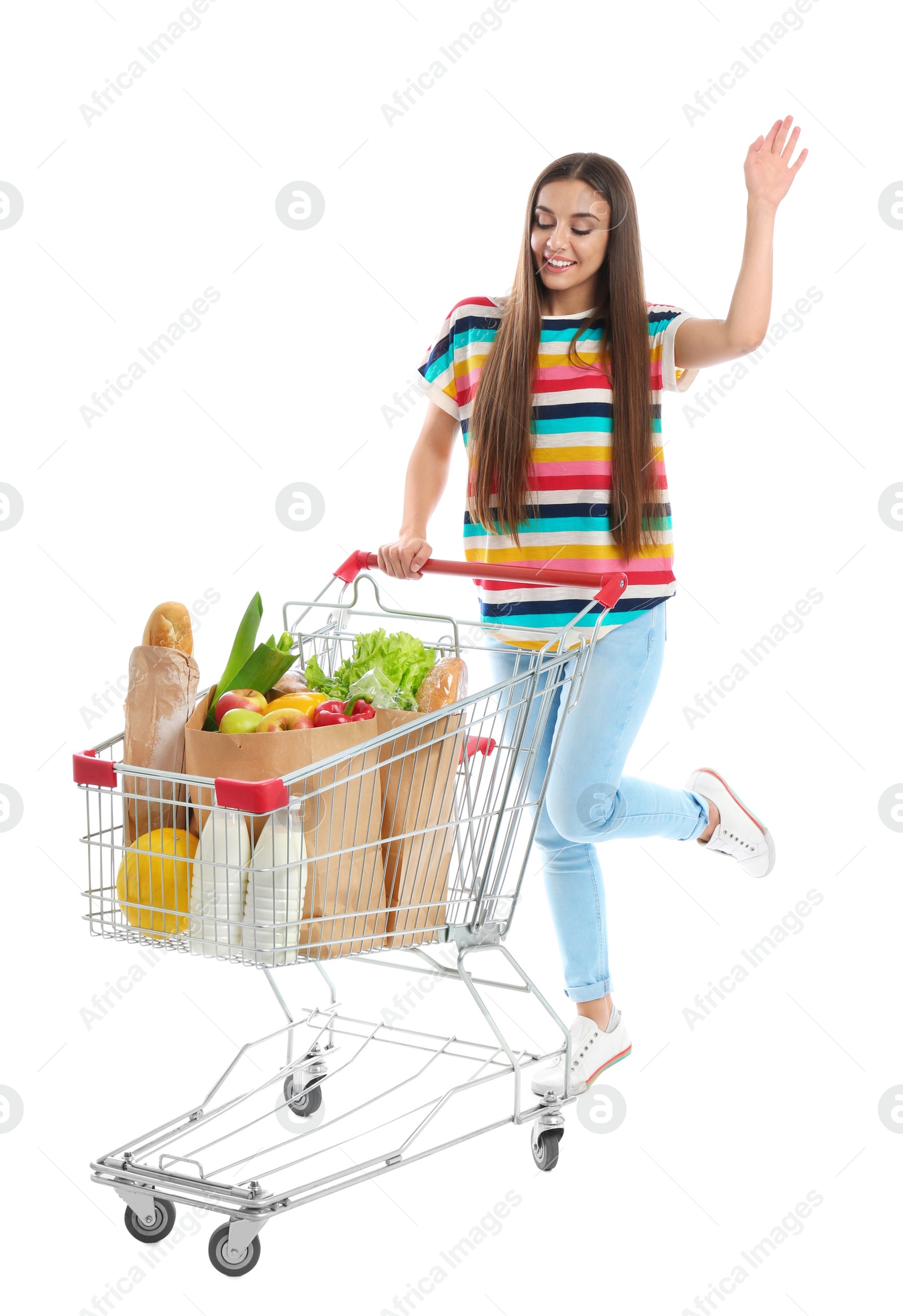 Photo of Young woman with full shopping cart on white background