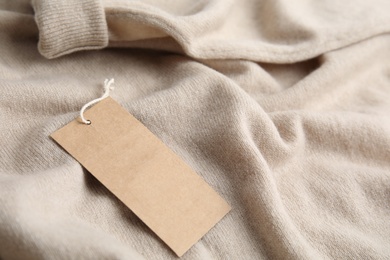 Photo of Warm beige cashmere sweater with tag, closeup