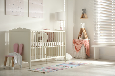 Photo of Cute baby room interior with crib and decor elements