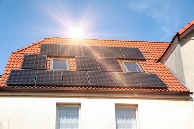 Photo of House with installed solar panels on roof. Alternative energy