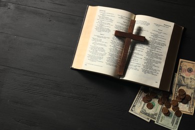 Photo of Donate and give concept. Coins, dollar banknotes, cross and Bible on black wooden table, flat lay. Space for text