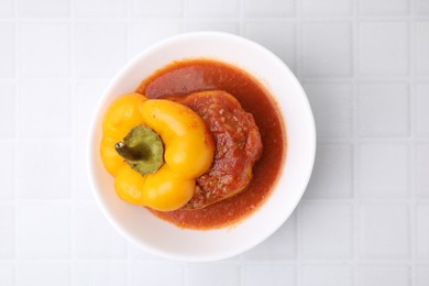 Photo of Delicious stuffed bell pepper on white tiled table, top view