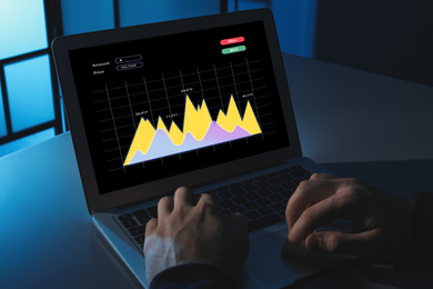 Image of  Broker working with laptop at table, closeup. Forex trading