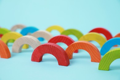 Colorful wooden pieces of playing set on light blue background. Educational toy for motor skills development